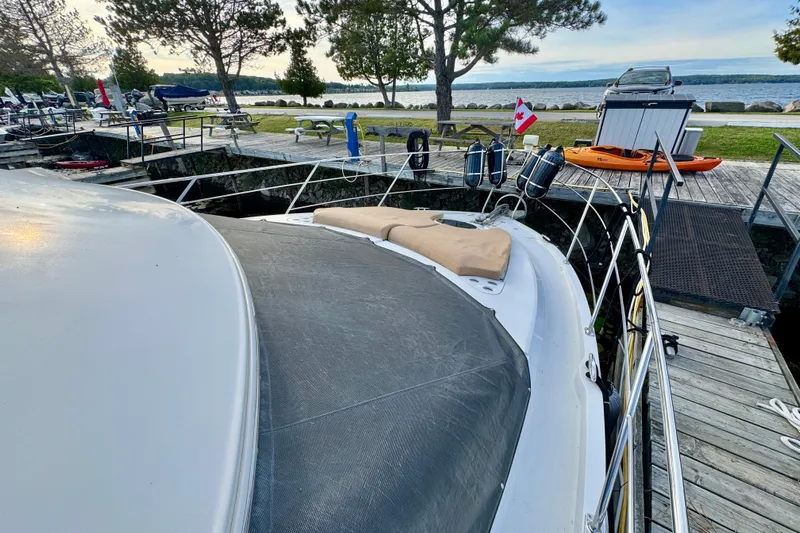 Water Music Yacht Photos Pics 2006 Carver 43 Motor Yacht docked by a scenic lakeside with trees and kayaks.