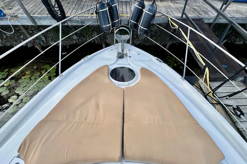 Water Music Yacht Photos Pics 2006 Carver 43 Motor Yacht bow with tan cushions, docked near water lilies.