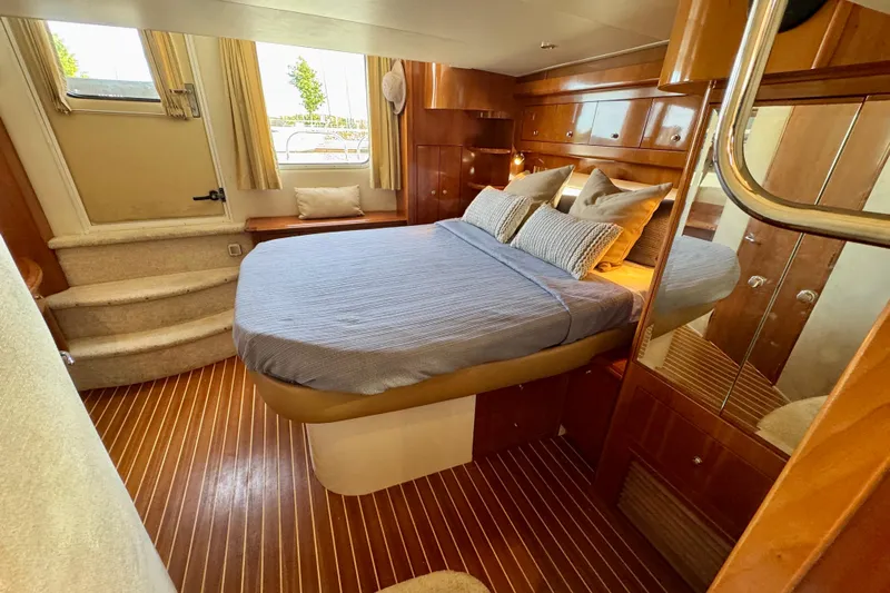 Water Music Yacht Photos Pics Luxurious 2006 Carver 43 Motor Yacht bedroom with elegant wood finishes and cozy bedding.