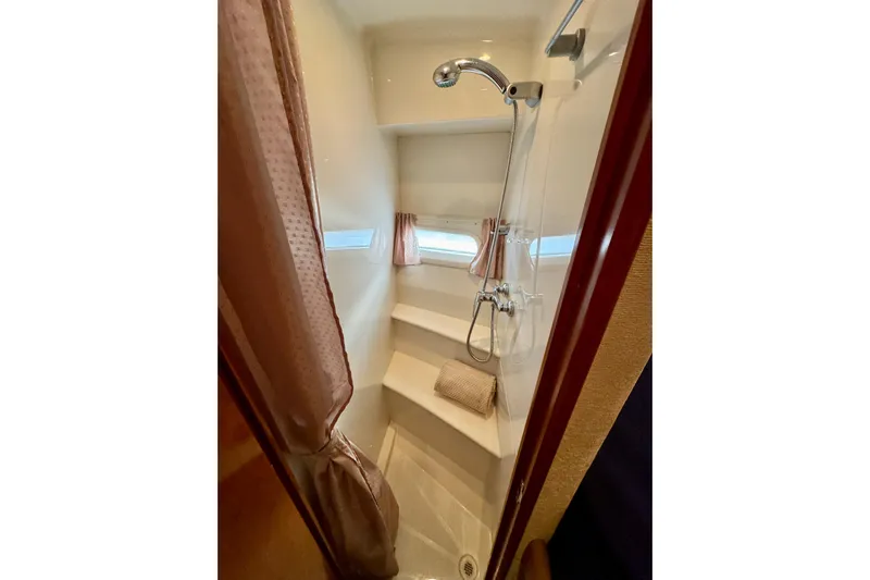 Water Music Yacht Photos Pics 2006 Carver 43 Motor Yacht shower with curtain, window, and chrome fixtures.