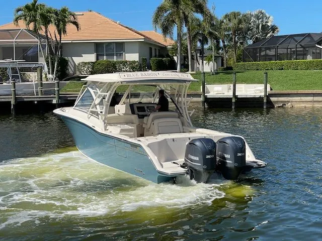  Yacht Photos Pics 2021 Grady-White 325 Freedom boat on water with palm trees.
