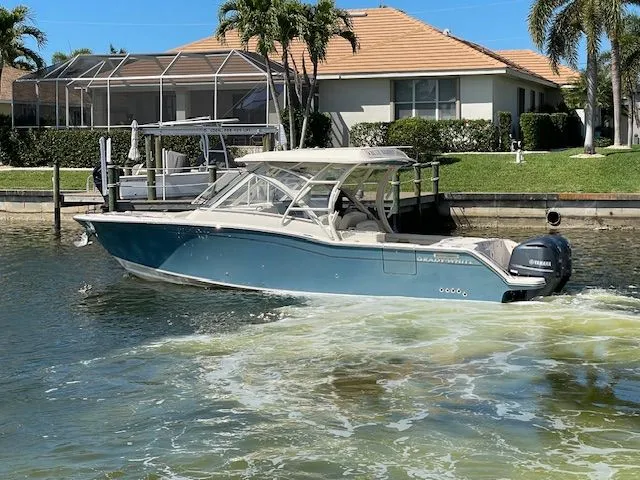  Yacht Photos Pics 2021 Grady-White 325 Freedom boat on water near coastal home.