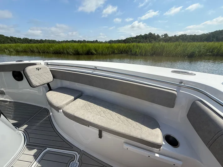  Yacht Photos Pics 2024 Sea Pro 262DLX boat interior with cushioned seating, near lush green marshland.