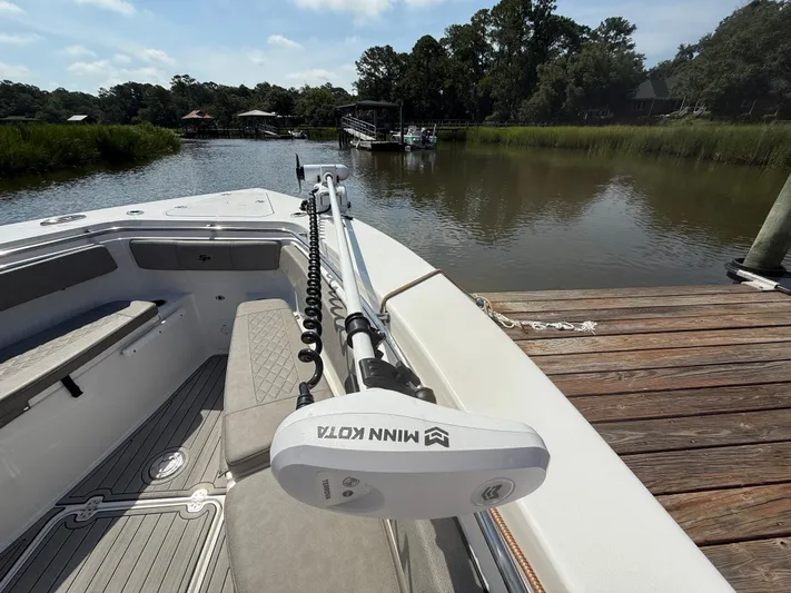  Yacht Photos Pics 2024 Sea Pro 262DLX boat docked by a serene river with lush greenery.