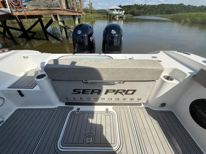  Yacht Photos Pics 2024 Sea Pro 262DLX boat with dual Suzuki engines, docked by a wooden pier.