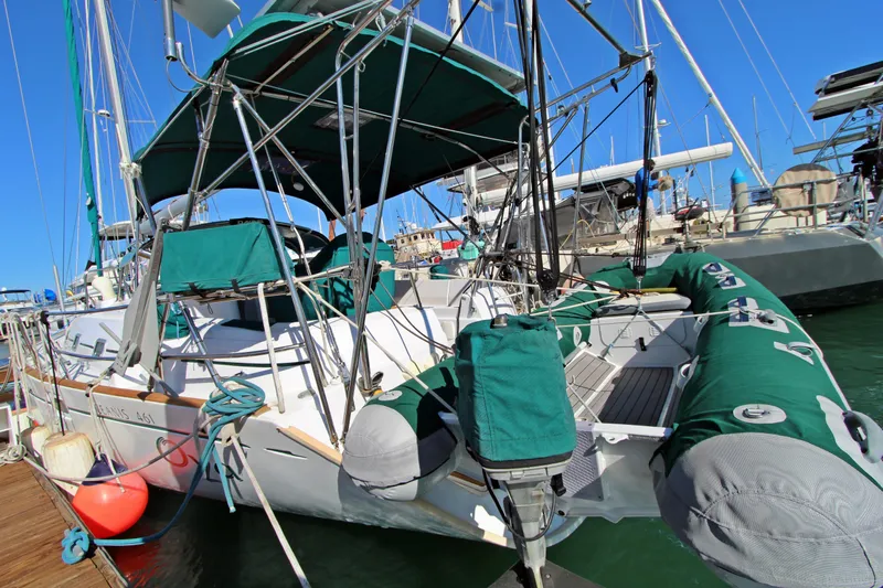  Yacht Photos Pics 2001 Beneteau Oceanis 461 sailboat docked, featuring green covers and inflatable dinghy.