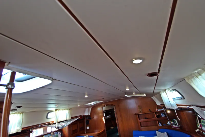  Yacht Photos Pics Interior of 2001 Beneteau Oceanis 461 sailboat, featuring wooden paneling and cozy seating area.