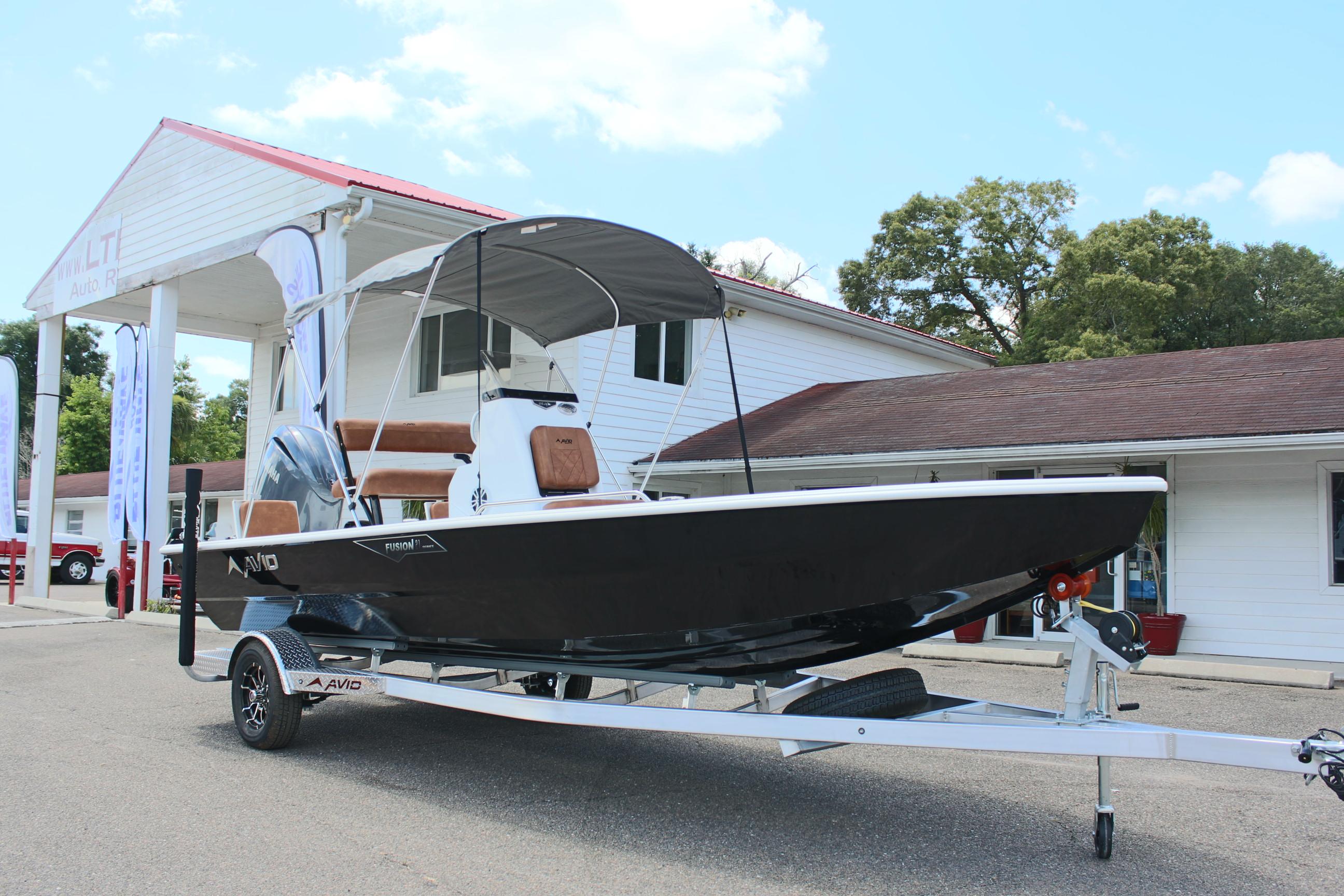 2024 Avid 21 Fusion boat on a trailer outside a dealership.