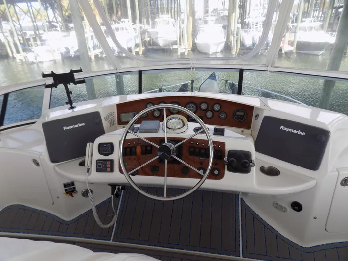  Yacht Photos Pics 2005 Silverton 43 Motor Yacht helm with Raymarine navigation system and classic wooden dashboard.