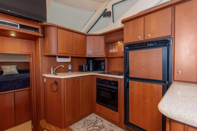  Yacht Photos Pics 2005 Silverton 43 Motor Yacht kitchen with wood cabinetry, appliances, and countertop.