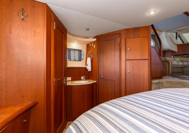  Yacht Photos Pics Interior of 2005 Silverton 43 Motor Yacht with wood cabinetry and striped bedding.