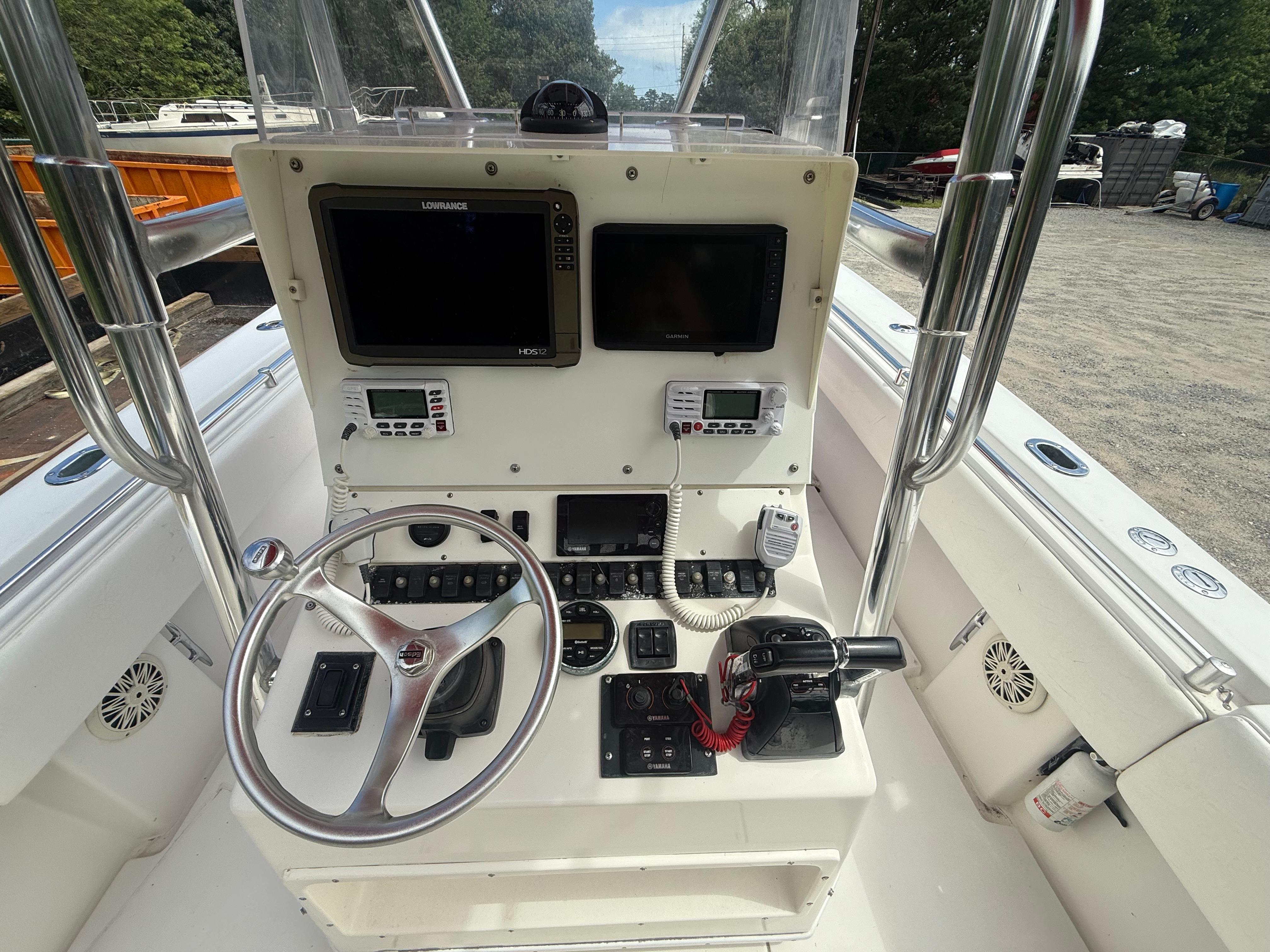 Center console of a 2002 Contender 27 Tournament boat with navigation equipment and steering wheel.