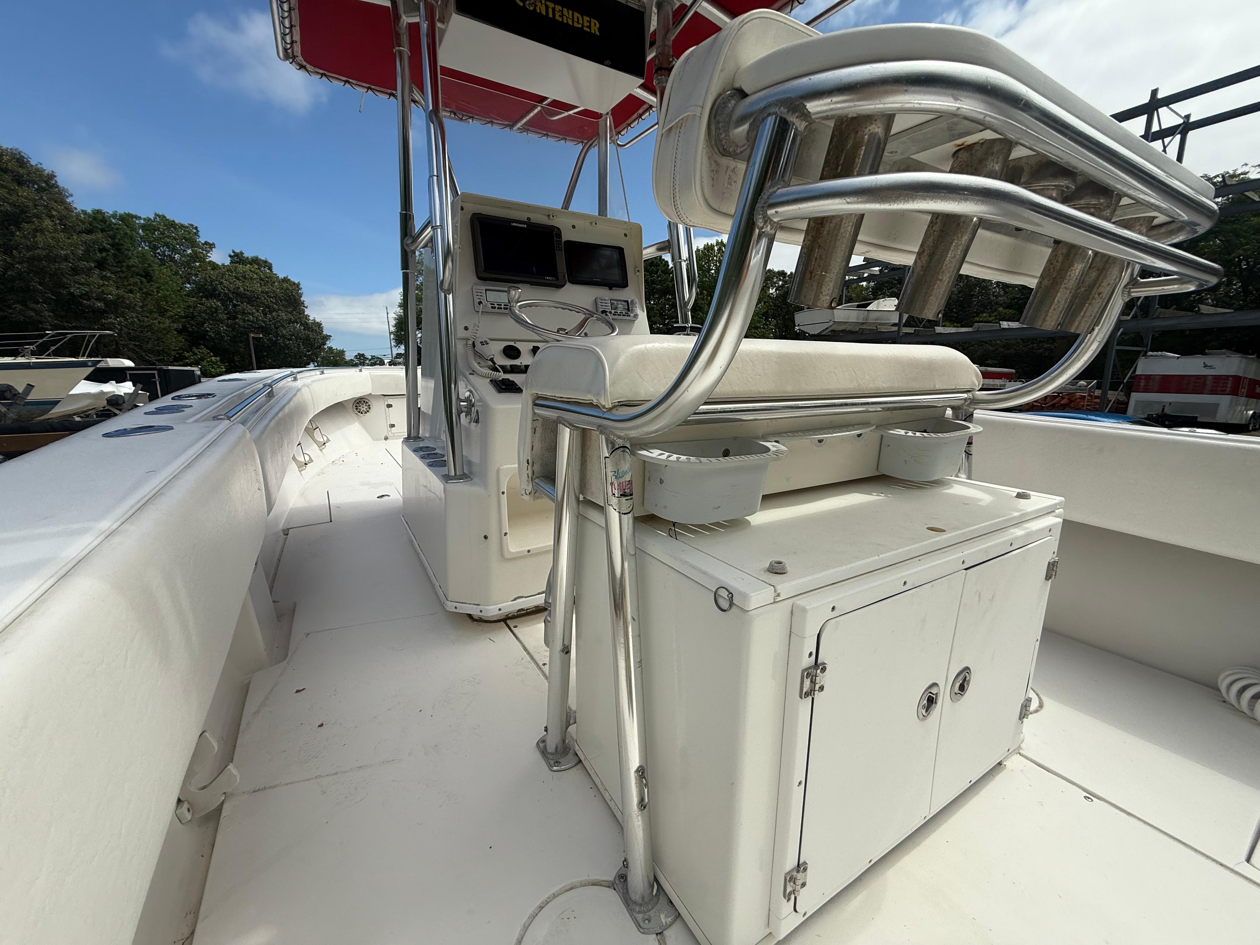 2002 Contender 27 Tournament boat interior with helm and seating, featuring rod holders and storage.
