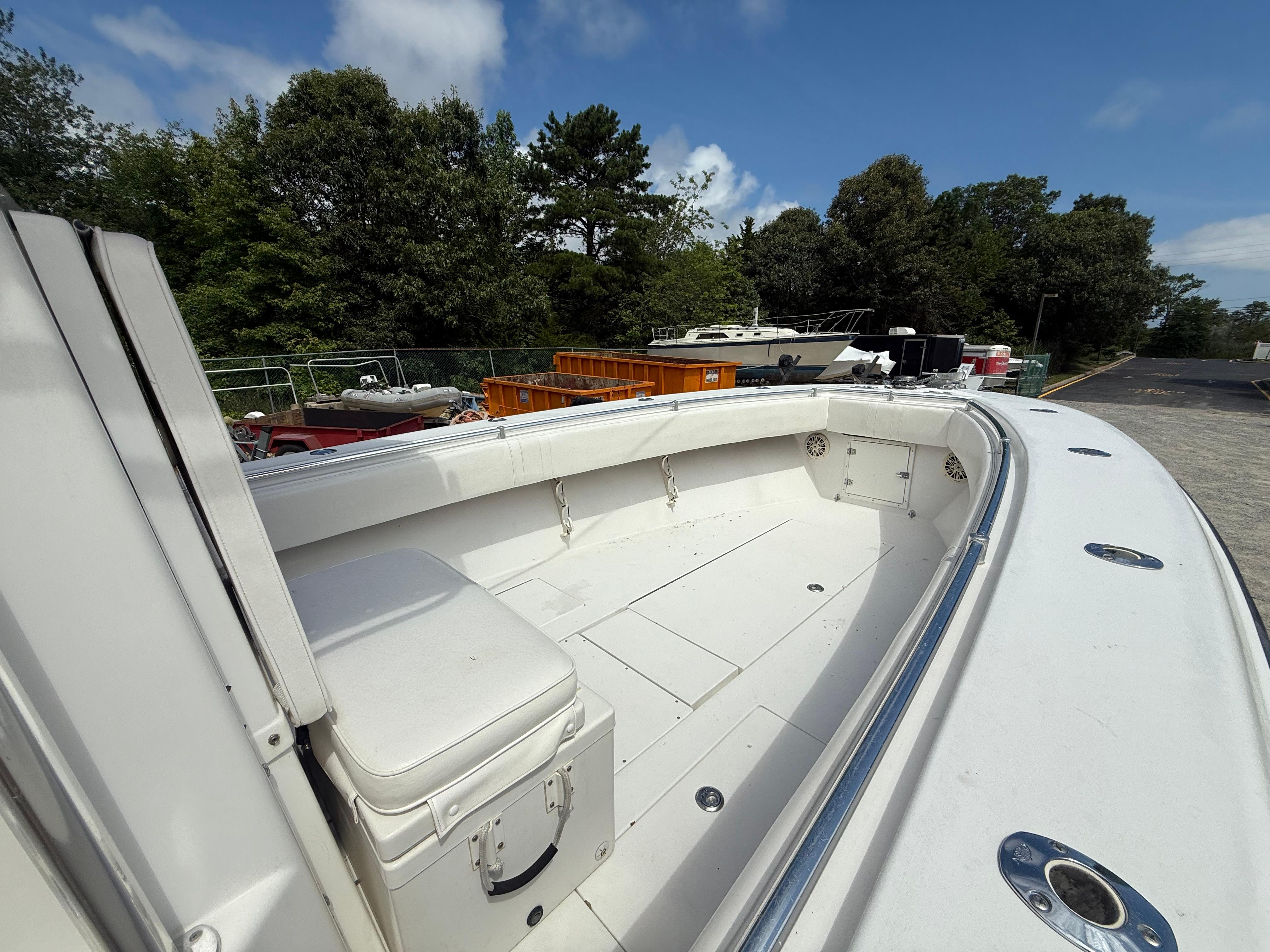 2002 Contender 27 Tournament boat with spacious deck, surrounded by trees and other boats.