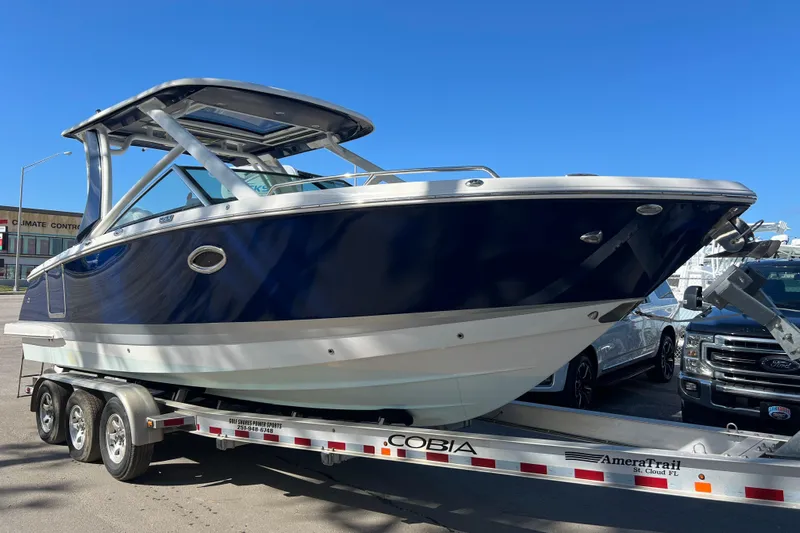  Yacht Photos Pics 2020 Chaparral 280 OSX boat on trailer, sleek design, blue and white exterior.