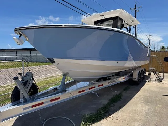 2025 Robalo R300 Center Console boat on trailer, parked outdoors.
