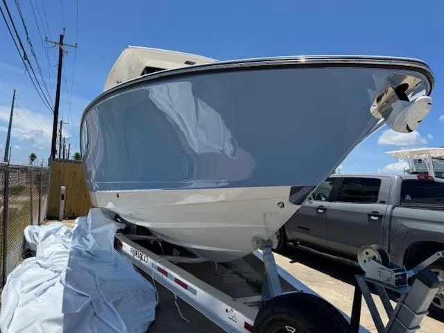 2025 Robalo R300 Center Console boat on trailer, parked outdoors under clear blue sky.