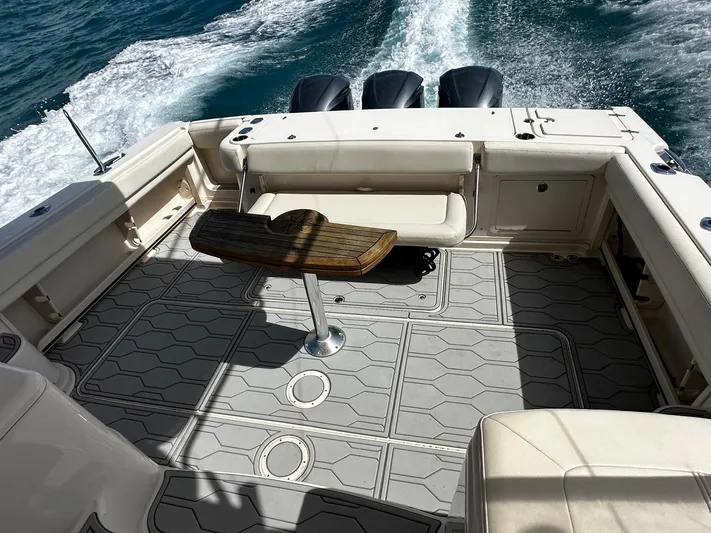  Yacht Photos Pics Grady-White Express 370 boat deck with seating and table, cruising on open water.