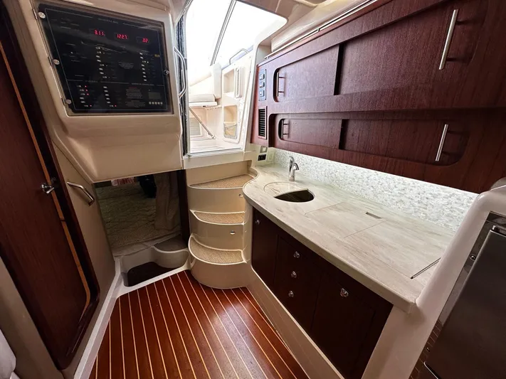  Yacht Photos Pics 2016 Grady-White Express 370 interior with wood cabinetry, compact kitchen, and control panel.