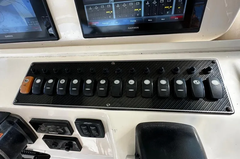 Yacht Photos Pics Control panel of a 2016 Grady-White Express 370 boat with multiple switches and screens.