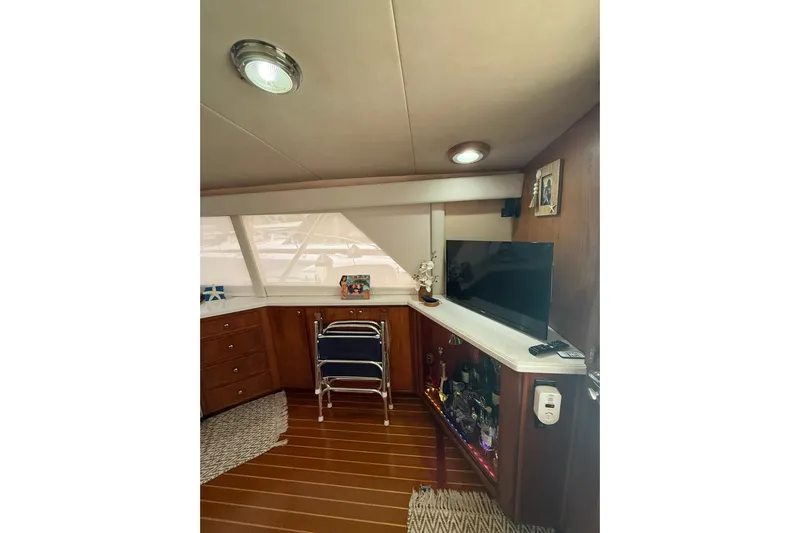  Yacht Photos Pics Interior of 1988 Bertram 43 Flybridge with TV, bar, and wooden cabinetry.