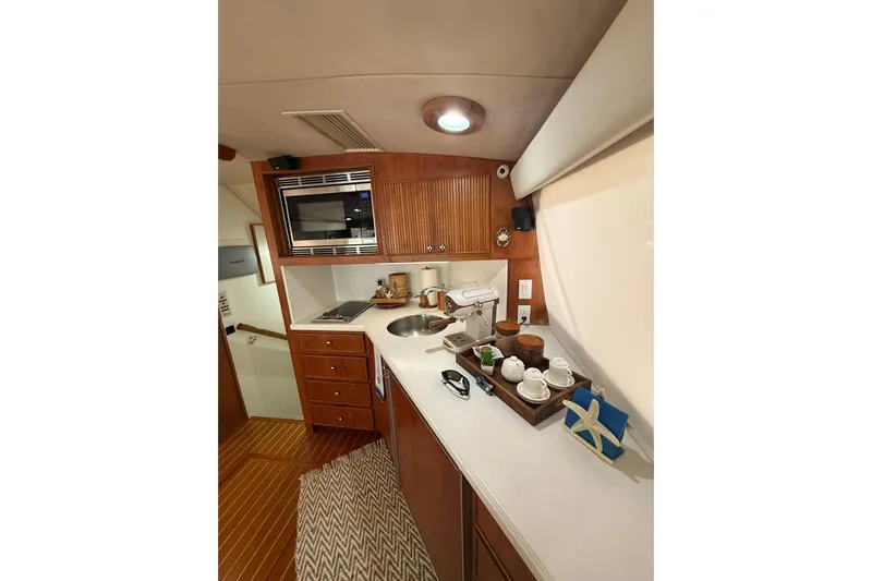  Yacht Photos Pics Interior of 1988 Bertram 43 Flybridge yacht kitchen with wooden cabinetry and modern appliances.