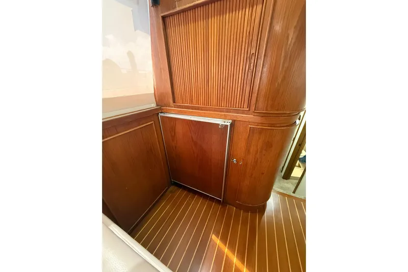  Yacht Photos Pics 1988 Bertram 43 Flybridge interior with wooden cabinetry and flooring.