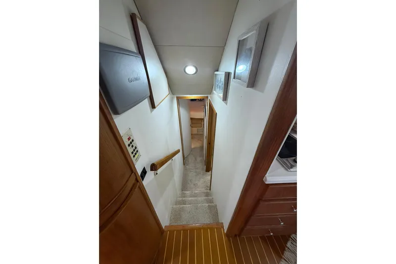  Yacht Photos Pics Interior hallway of 1988 Bertram 43 Flybridge yacht, featuring stairs and wooden accents.