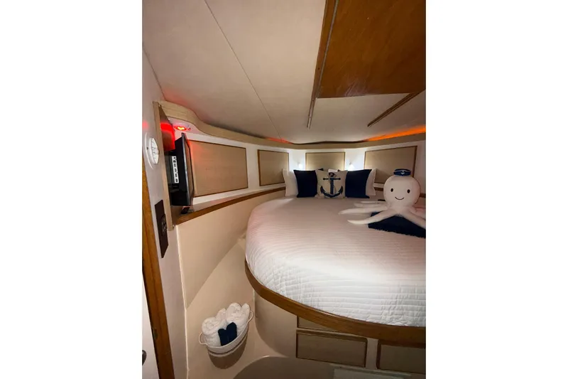  Yacht Photos Pics Cozy cabin interior of 1988 Bertram 43 Flybridge with nautical decor and plush bedding.