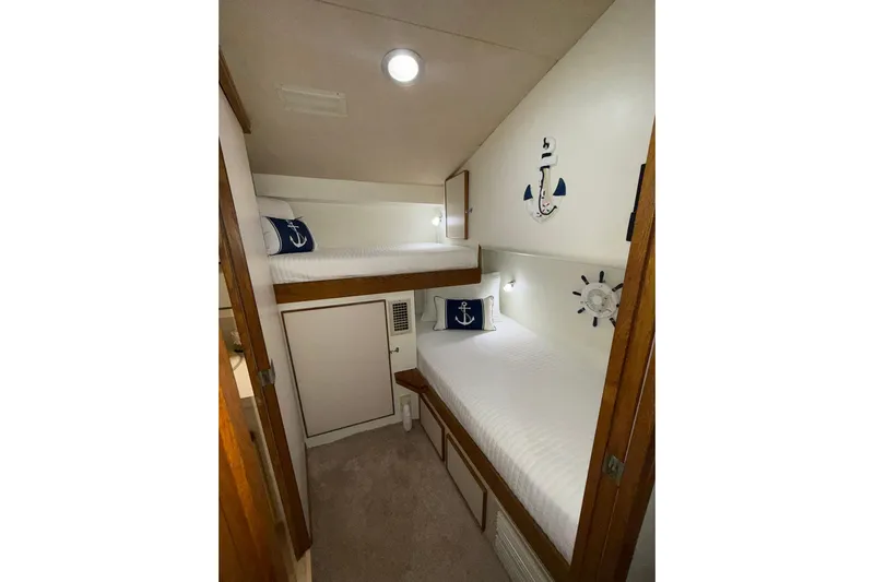  Yacht Photos Pics 1988 Bertram 43 Flybridge cabin with nautical-themed bunk beds and anchor decor.