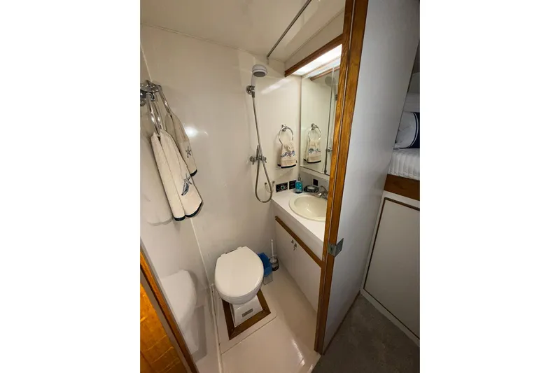  Yacht Photos Pics Compact bathroom in 1988 Bertram 43 Flybridge yacht with shower, sink, and toilet.