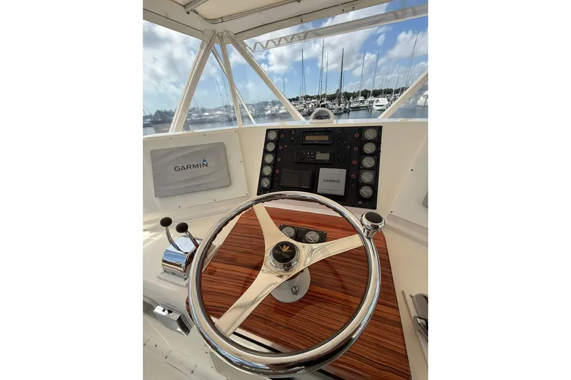  Yacht Photos Pics 1988 Bertram 43 Flybridge helm with Garmin navigation, marina view in background.