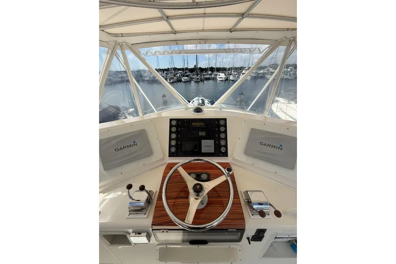  Yacht Photos Pics 1988 Bertram 43 Flybridge helm with Garmin navigation, overlooking marina.