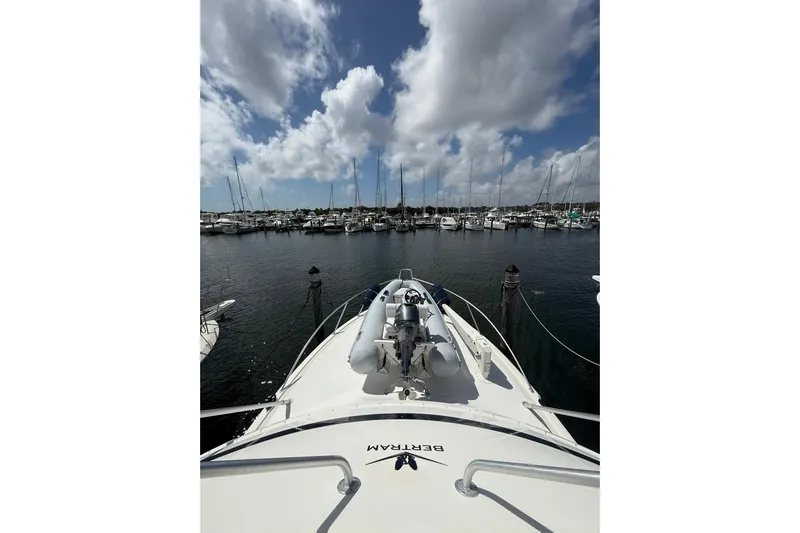  Yacht Photos Pics 1988 Bertram 43 Flybridge yacht docked in a marina under a cloudy sky.