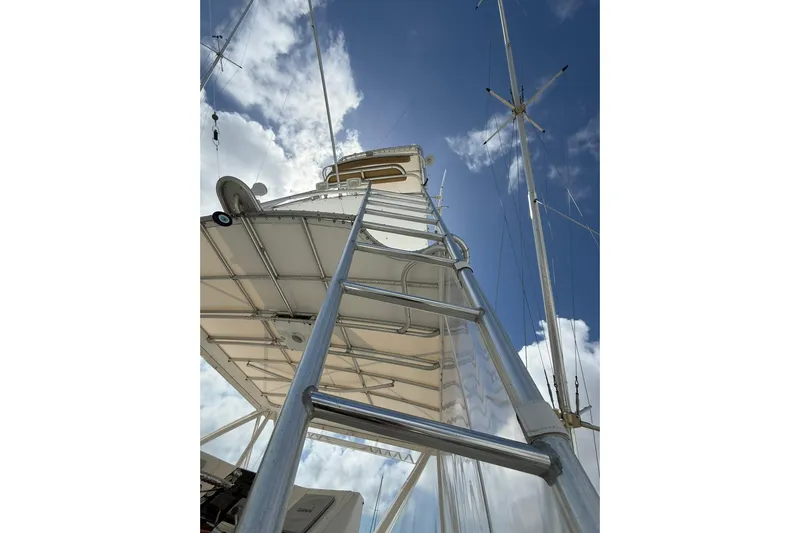  Yacht Photos Pics Ladder view on 1988 Bertram 43 Flybridge against blue sky and clouds.