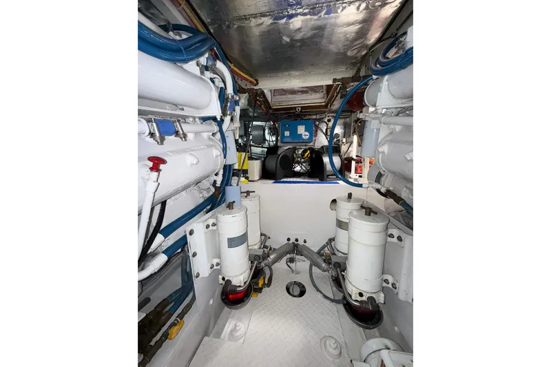  Yacht Photos Pics Engine room of a 1988 Bertram 43 Flybridge, showcasing mechanical components and piping.