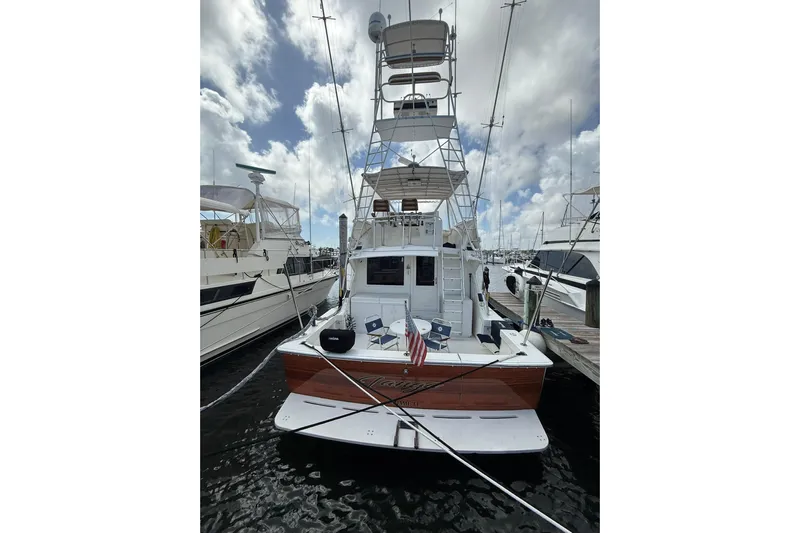  Yacht Photos Pics 1988 Bertram 43 Flybridge yacht docked at marina under cloudy sky.