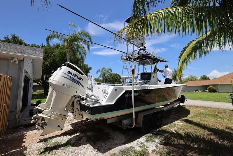 Late Fees Yacht Photos Pics 2001 Contender 27 Open boat with Suzuki outboard motor on trailer.