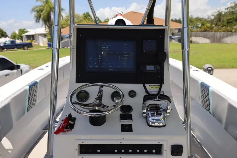 Late Fees Yacht Photos Pics 2001 Contender 27 Open boat dashboard with steering wheel and electronic controls.