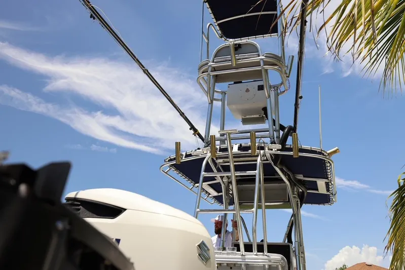 Late Fees Yacht Photos Pics 2001 Contender 27 Open boat with tower and equipment against blue sky.