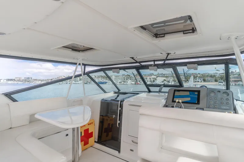 Half Dozen Yacht Photos Pics Interior of 2001 Tiara Yachts 4100 Open, featuring helm and seating area with marina view.