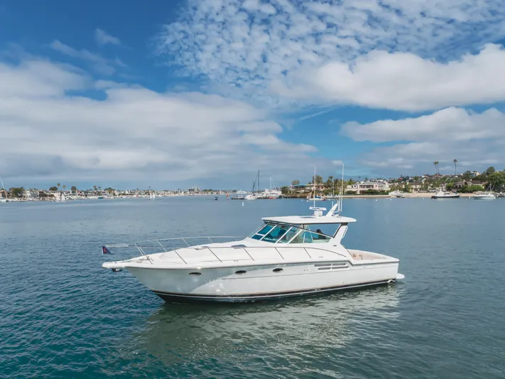 Half Dozen Yacht Photos Pics 2001 Tiara Yachts 4100 Open cruising on a calm, scenic bay under a partly cloudy sky.