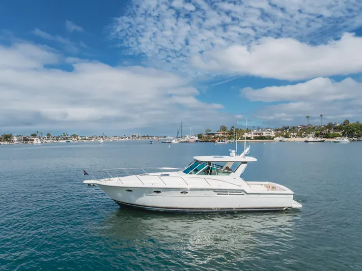 Half Dozen Yacht Photos Pics 2001 Tiara Yachts 4100 Open cruising on a sunny day with coastal backdrop.