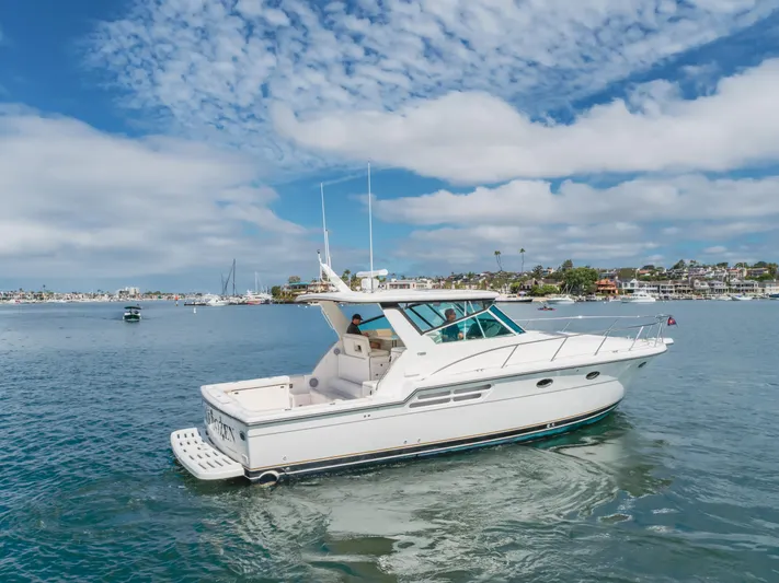 Half Dozen Yacht Photos Pics 2001 Tiara Yachts 4100 Open cruising on a sunny day with scenic coastal backdrop.