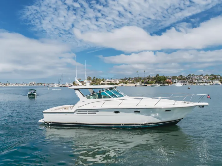Half Dozen Yacht Photos Pics 2001 Tiara Yachts 4100 Open cruising on a sunny day, coastal background.