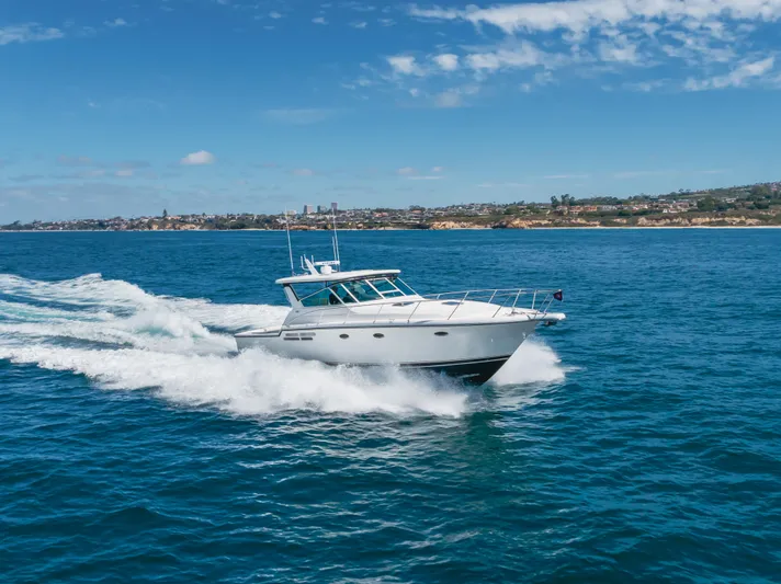 Half Dozen Yacht Photos Pics 2001 Tiara Yachts 4100 Open cruising on blue ocean near coastline.