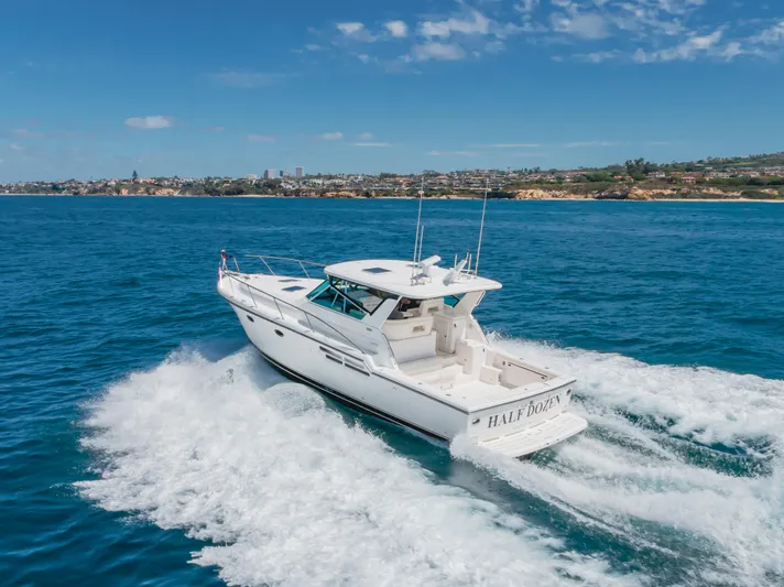 Half Dozen Yacht Photos Pics 2001 Tiara Yachts 4100 Open cruising on blue ocean near coastline.