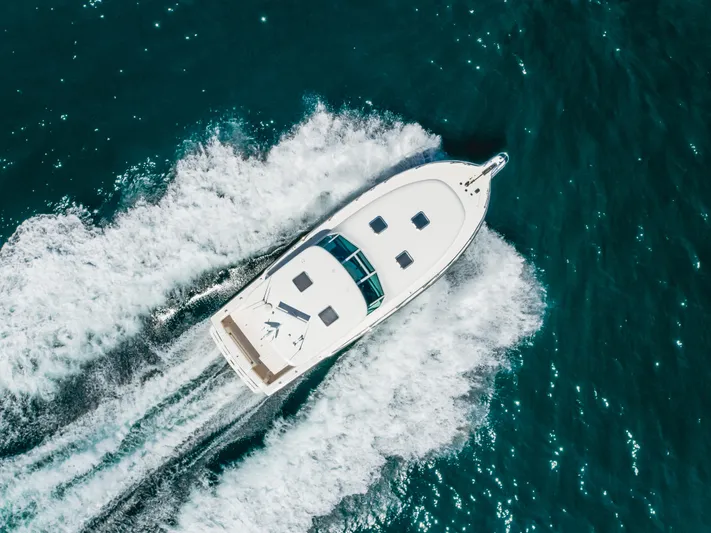Half Dozen Yacht Photos Pics Aerial view of 2001 Tiara Yachts 4100 Open cruising on blue ocean waters.