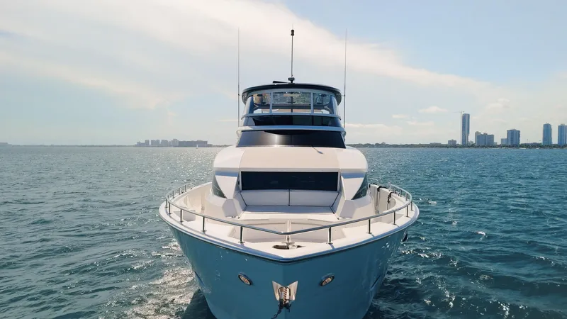  Yacht Photos Pics 2017 Hatteras M75 Panacera yacht cruising on open water with city skyline in background.