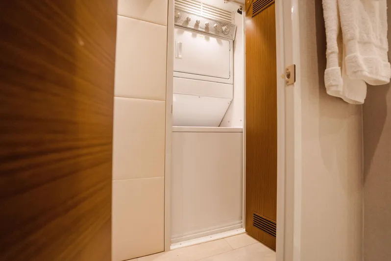  Yacht Photos Pics Laundry area inside 2017 Hatteras M75 Panacera yacht, featuring a compact washer and dryer.